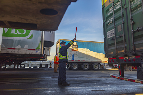 man directing trailer with red baton