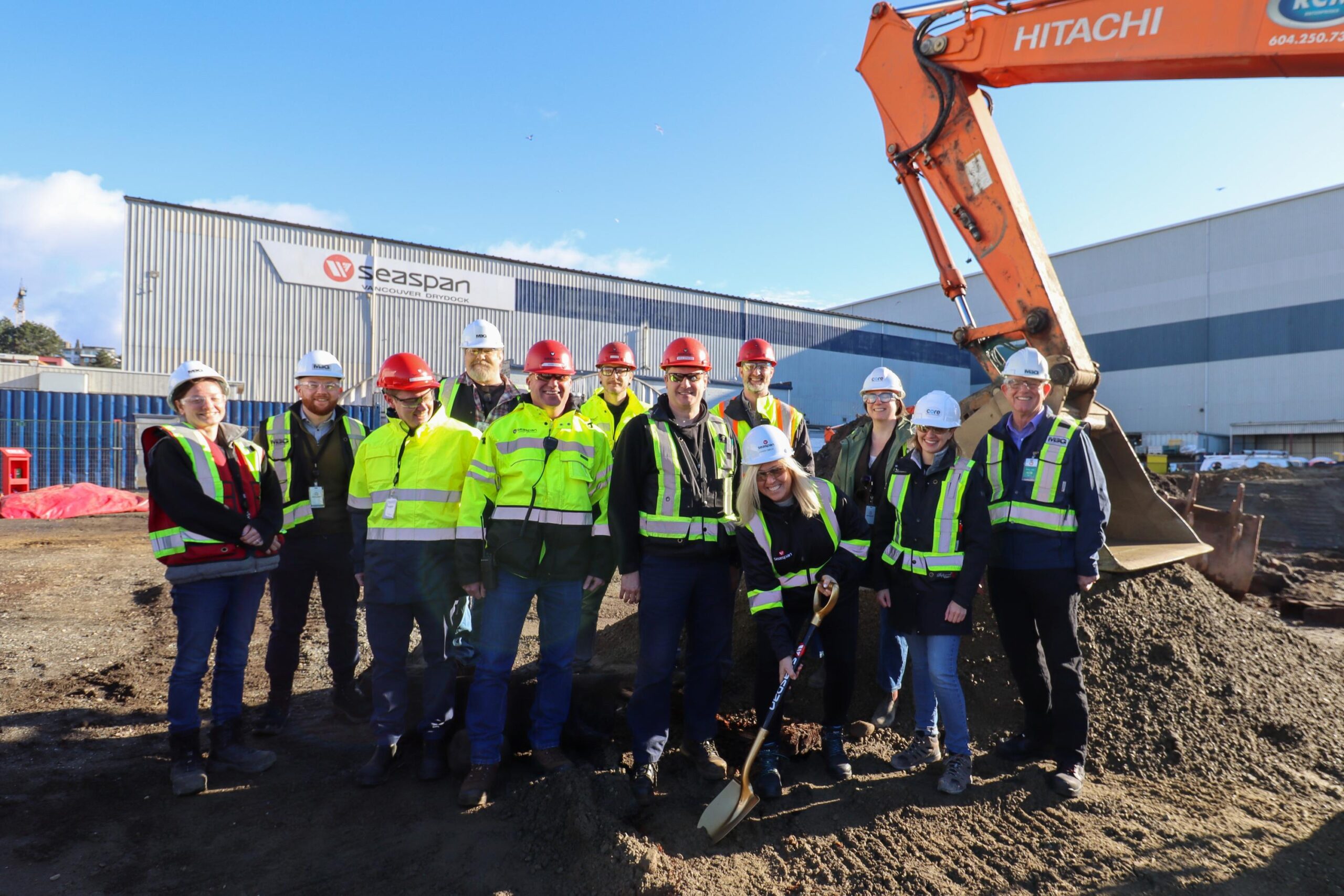 Group of people performing groundbreaking ceremony with golden shovel