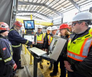 group of people watching tradesperson push button