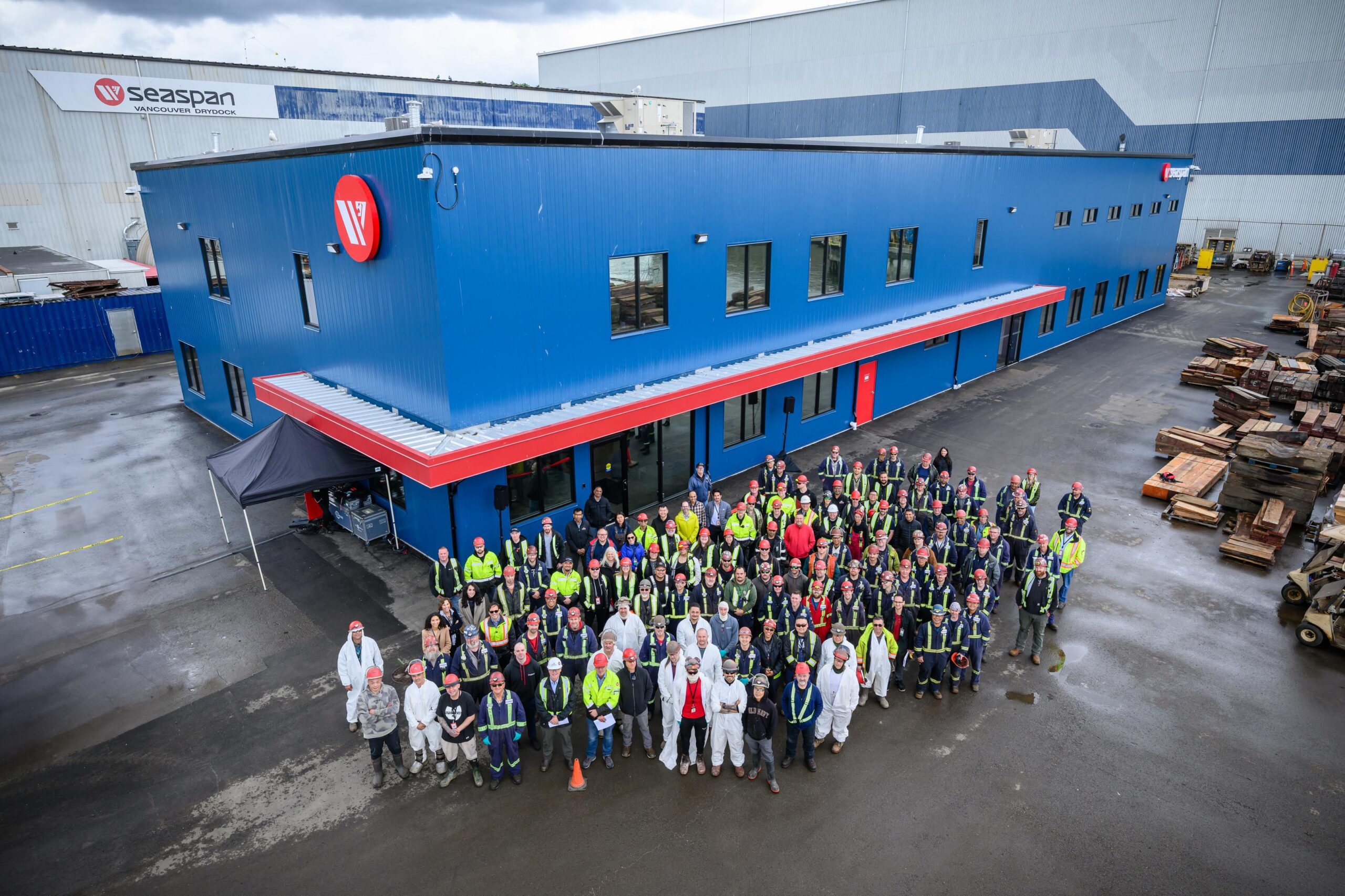 Photo of large group of skilled trades employees in front of new Vancouver Drydock building