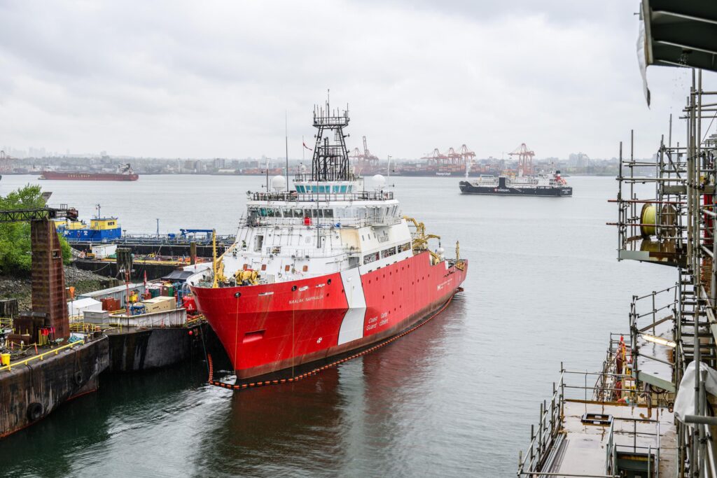 OOSV docked in foreground with Seaspan Energy vessel sailing in Port in background