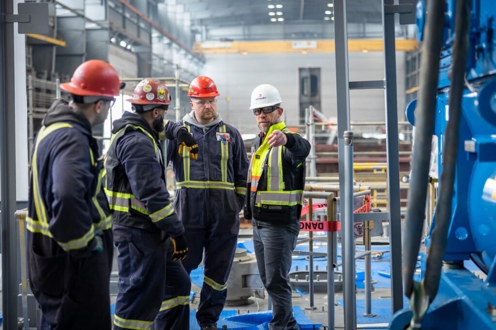 group of people in hardhats, one white and three red