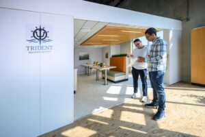 Seaspan employee and Trident employee review designs while standing in front of the mock-up cabin 