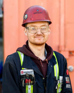 Victoria shipyards worker with red hard hat and coveralls