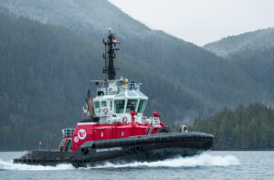 A tugboat in the water against a backdrop of mountains