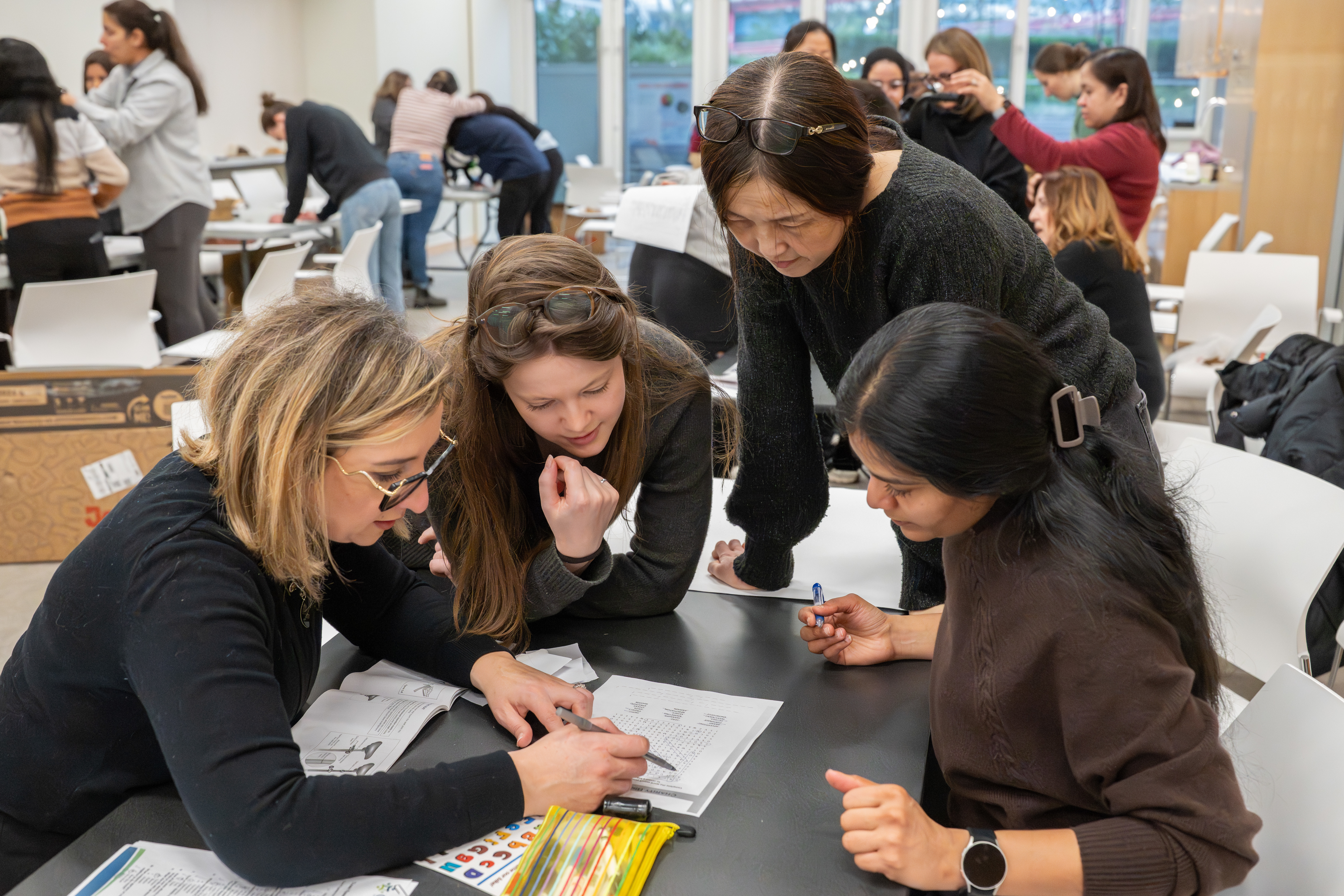 A group of women pore over a sheet of paper together