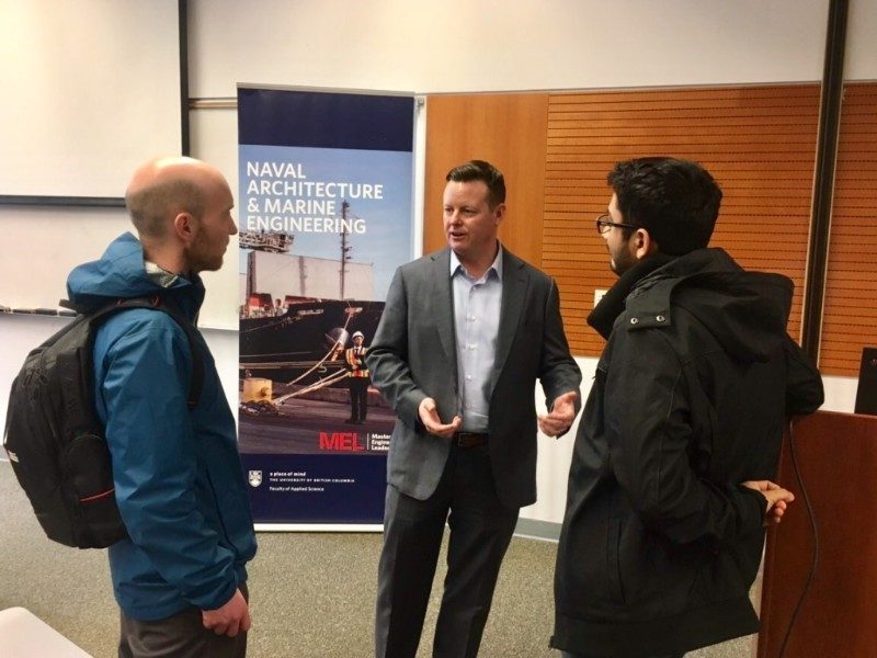 Brian Carter speaking to two students.